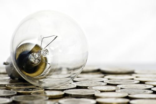 Glühbirne liegt auf Geld